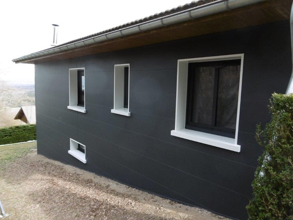3 fenêtres blanches sur une façade de maison nouvellement isolée